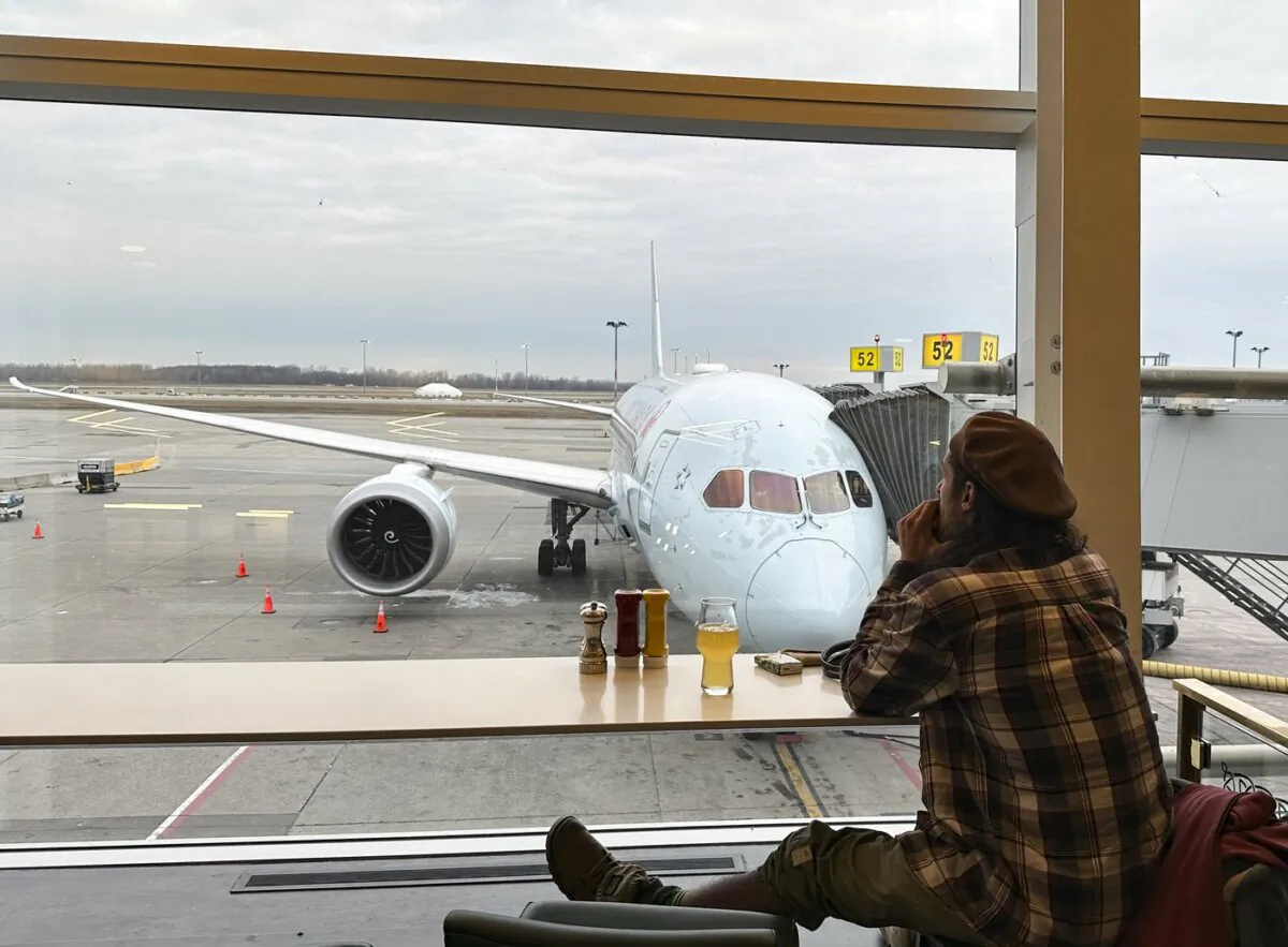 A traveller looks at an Air Canada plane as he waits for his flight at Pierre Elliott Trudeau International Airport in Montreal, on Dec. 23, 2023. (The Canadian Press/Christinne Muschi)