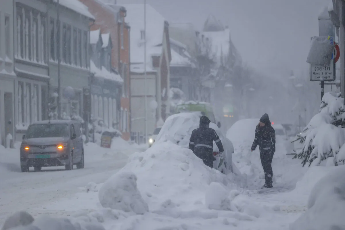 People attempt to clear the snow off a vehicle in Kristiansand, Norway, on Jan. 2, 2024. (Tor Erik Schrøder/NTB Scanpix via AP)