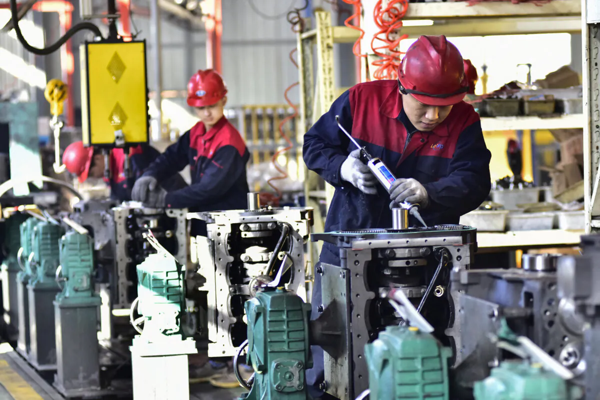 Employees work on engines at a factory in Qingzhou, in China's eastern Shandong province on Nov. 30, 2023. (STR/AFP via Getty Images)