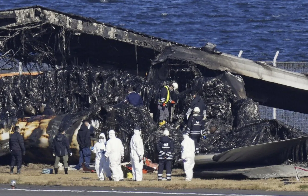 Officials investigate the wreckage of Japan Airlines plane at Haneda airport in Tokyo on Jan. 4, 2024. (The Canadian Press/Kyodo News via AP)