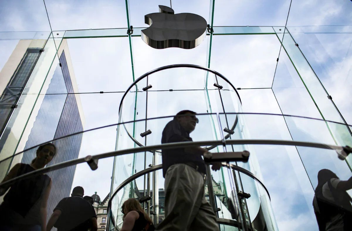 Customers enter the Apple store on 5th Avenue beneath an Apple logo in the Manhattan borough of New York City on July 21, 2015. (Mike Segar/Reuters)