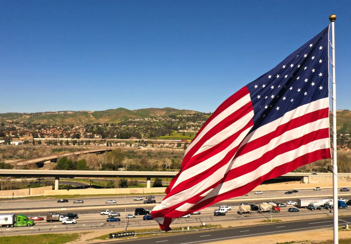 Cars and trucks drive past an American flag on the 91 Freeway in Anaheim Hills, Calif., on Feb. 8, 2023. (Patrick T. Fallon/AFP via Getty Images)