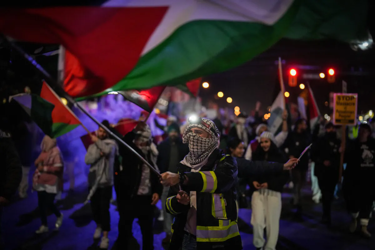 People wave Palestinian flags while marching after a pro-Palestinian demonstration in Vancouver on Oct. 19, 2023. (The Canadian Press/Darryl Dyck)