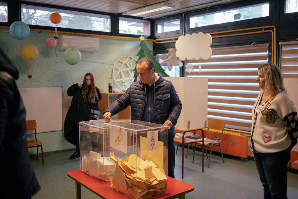 A voter casts his ballot in a ballot box at a polling station during parliamentary and local elections in Belgrade, Serbia, on Dec. 17, 2023. (Vladimir Zivojinovic/Getty Images)