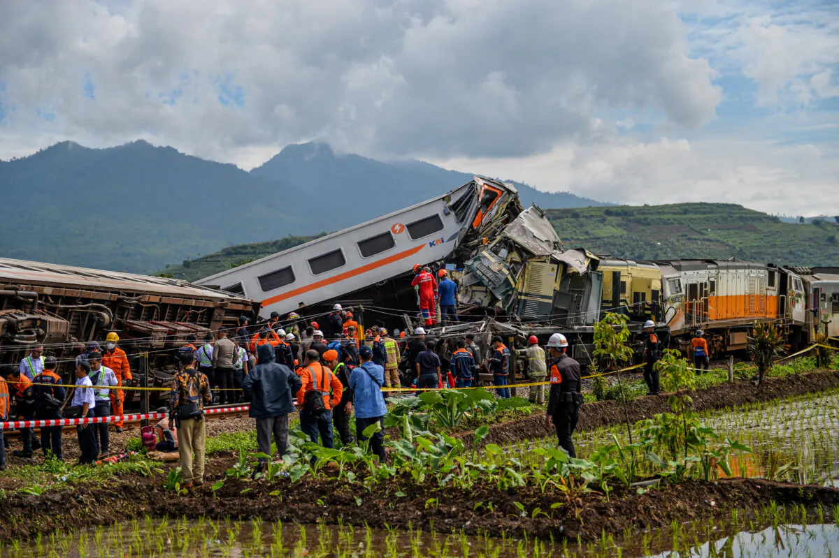 People stand at the site of a train collision between the local Bandung Raya train and the Turangga train in Cicalengka, Bandung, West Java Province, Indonesia, on Jan. 5, 2024. (Antara Foto/Raisan Al Farisi/via Reuters)