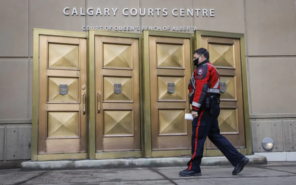 A police officer enters the Calgary Courts Centre in Calgary on Oct. 30, 2020. (The Canadian Press/Jeff McIntosh)