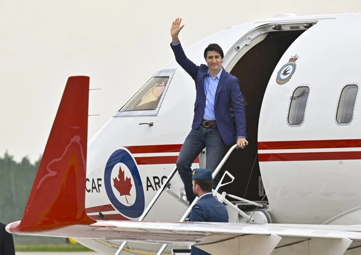 Prime Minister Justin Trudeau waves as he steps off a plane, June 14, 2023 at CFB Bagotville in Saguenay, Que. (The Canadian Press/Jacques Boissinot)