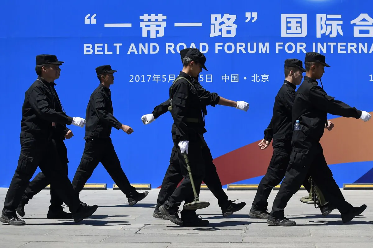 Security guards walk past a billboard for the Belt and Road Forum for International Cooperation at the forum's venue in Beijing on May 13, 2017.(Wang Zhao/AFP via Getty Images)