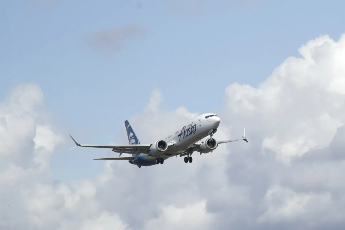 An Alaska Airlines Boeing 737-9 Max flies above Paine Field near Boeing's manufacturing facility in Everett, Wash., north of Seattle, on March 23, 2020. (Ted S. Warren/AP Photo, File)