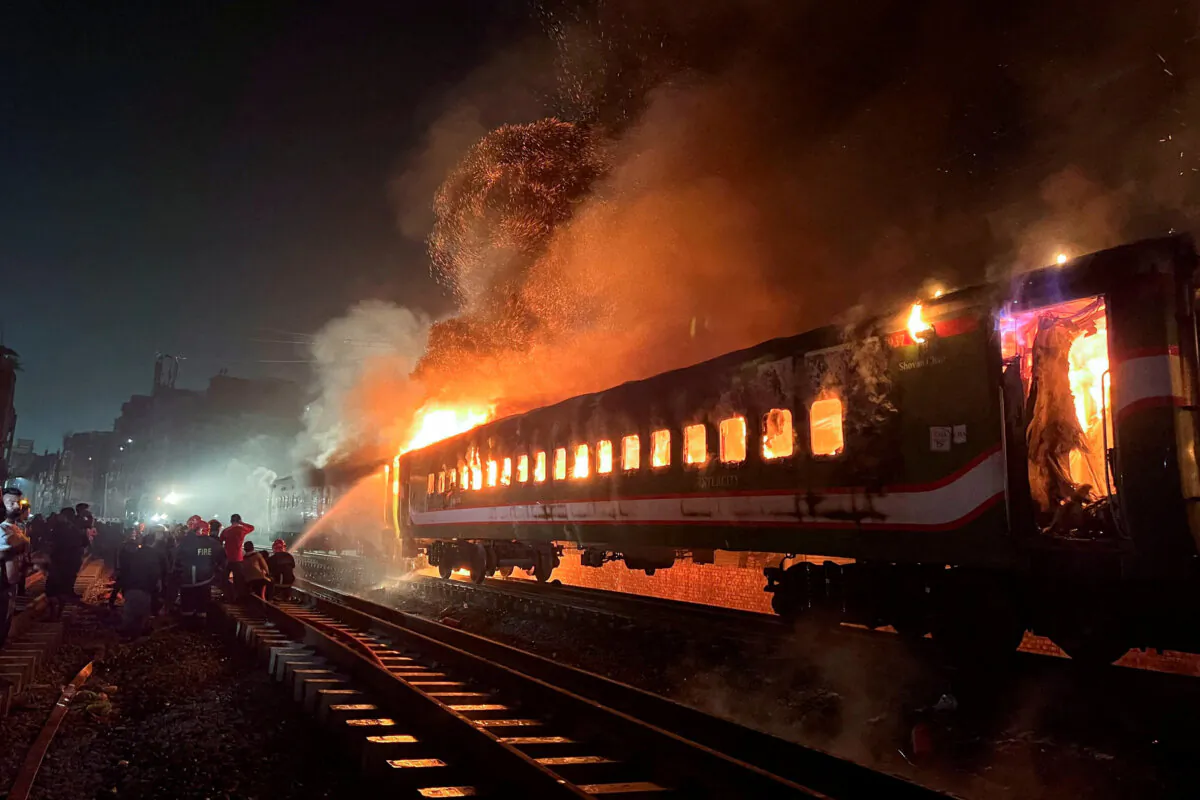 Firefighters try to extinguish a fire caught on a passenger train, ahead of the general election in Dhaka, Bangladesh, on Jan. 5, 2024. (Mohammad Ponir Hossain/Reuters)
