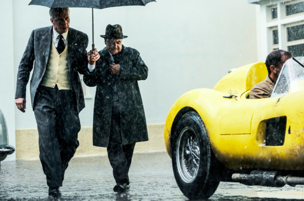 two men with umbrella, one man in yellow car in FERRARI