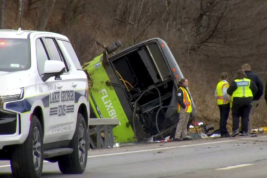 This still image from WTEN-TV video shows emergency response personnel at the site of a roll over bus accident on the Adirondack Northway, in the town of Lake George, N.Y., on Jan. 5, 2024. (The Canadian Press/WTEN-TV via AP)