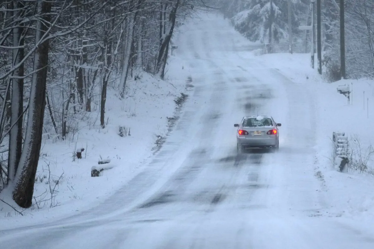 A car treks down a snow covered road in Derry, N.H., on Jan. 7, 2024. (Charles Krupa/AP Photo)