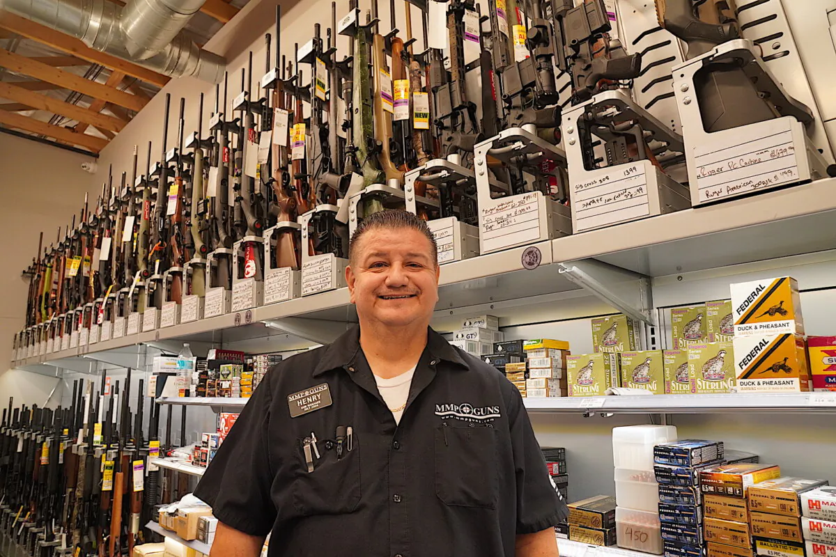 Henry Escobar, manager of MPP Guns in Phoenix, Ariz., stands behind the counter on Jan. 6, 2024. (Allan Stein/The Epoch Times)