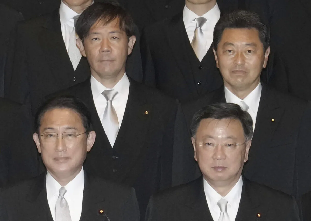 Japan's Lower House member Yoshitaka Ikeda, rear right, poses for a photograph with Prime Minister Fumio Kishida, bottom left, as he is sworn in as vice-education minister at Kishida's office in Tokyo, on Nov. 11, 2021. (Kyodo News via AP)