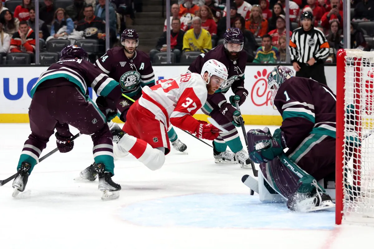 Adam Henrique (14) Radko Gudas (7) and Lukas Dostal (1) of the Anaheim Ducks defend against a shot on goal by J.T. Compher (37) of the Detroit Red Wings during the first period of a game in Anaheim, Calif., on Jan. 7, 2024. (Sean M. Haffey/Getty Images)