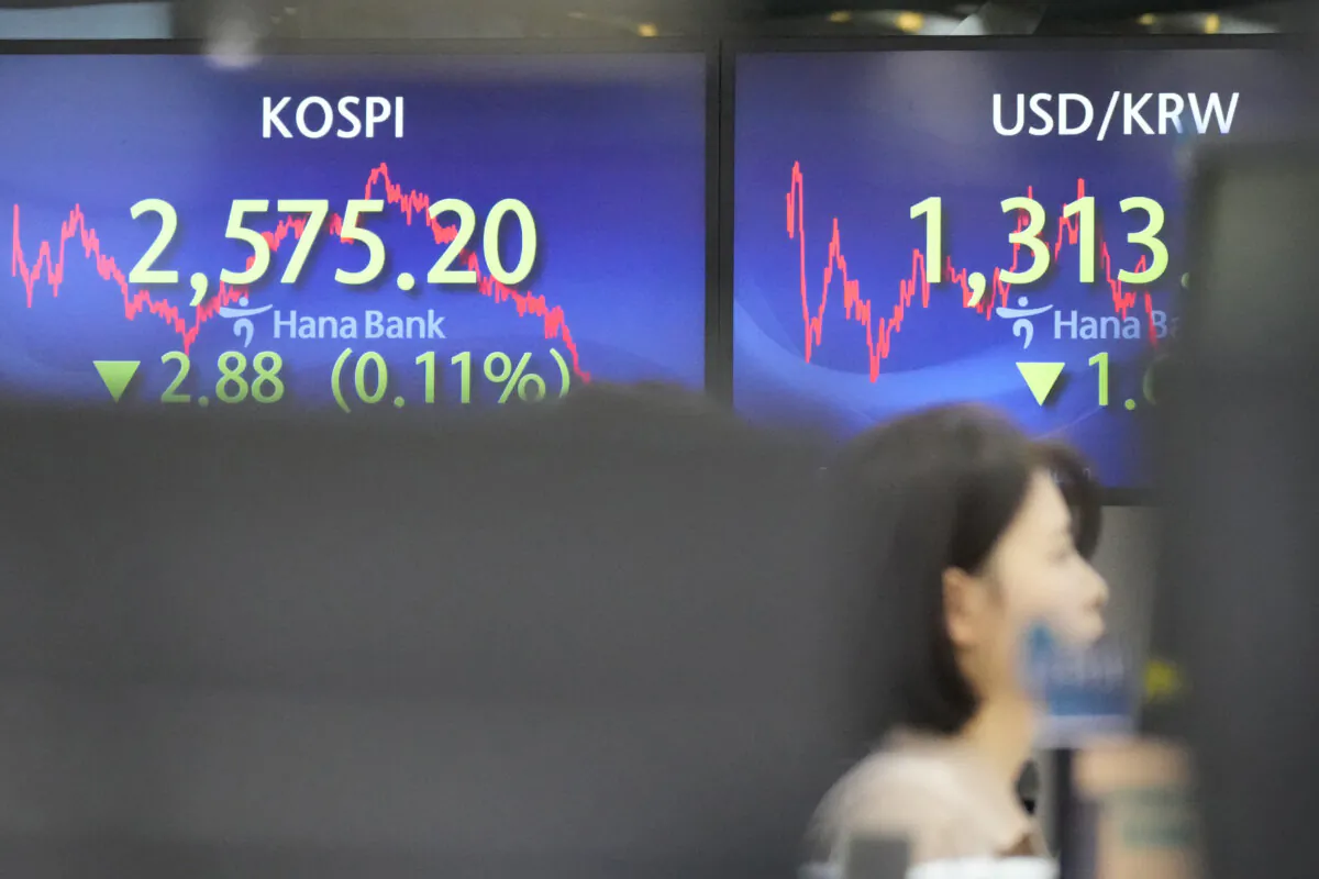 A currency trader watches computer monitors near the screens showing the Korea Composite Stock Price Index (KOSPI), (L), and the foreign exchange rate between U.S. dollar and South Korean won at a foreign exchange dealing room in Seoul, South Korea, on Jan. 8, 2024. (Lee Jin-man/AP Photo)