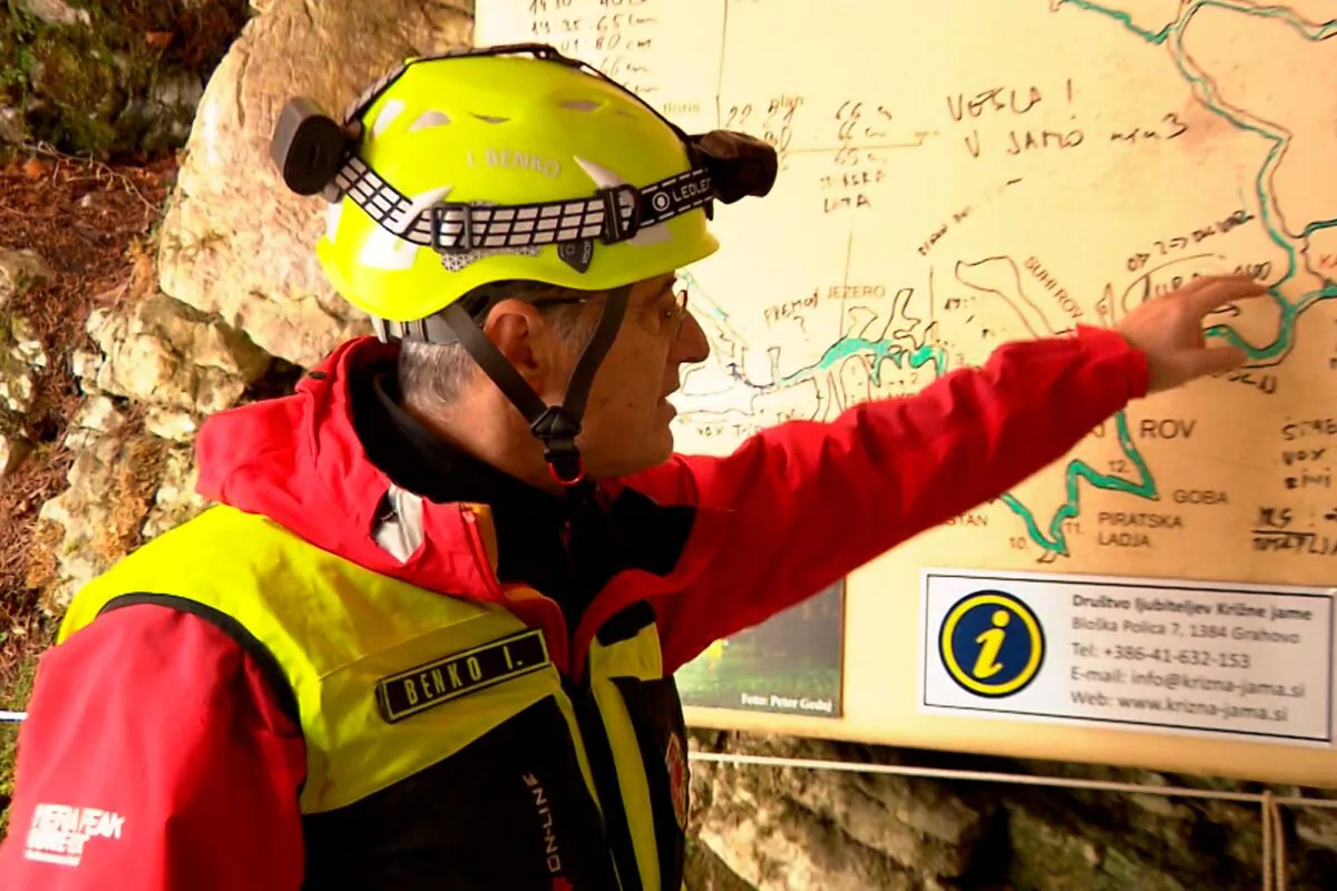 In this photo taken from video, a rescuer inspects the map of Krizna Jama cave near Grahovo, Slovenia, on Jan. 7, 2024. (Pop TV via AP)
