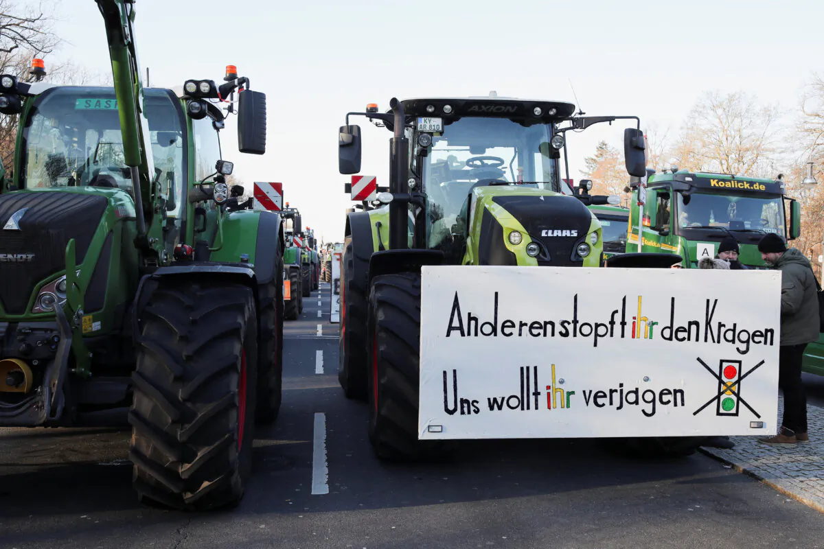 A banner on a tractor reads "You are feeding others and you want to chase us away" as German farmers protest against the cut of vehicle tax subsidies of the so-called German Ampel coalition government in Berlin on Jan. 8, 2024. (Nadja Wohlleben/Reuters)