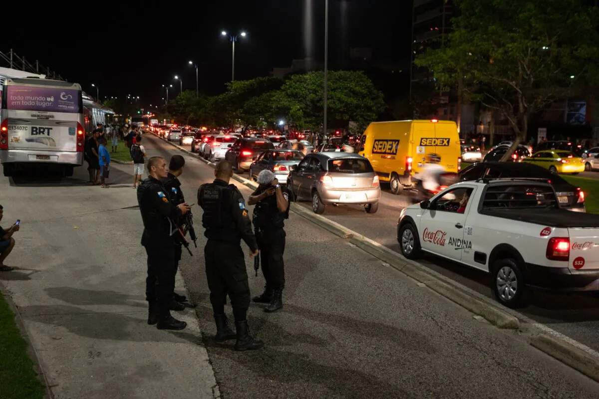Police stand guard as traffic remains at a standstill on Avenida das Americas, Recreio dos Bandeirantes, in western Rio de Janeiro on Oct. 23, 2023, after suspected paramilitary militia members torched 35 buses. (Tercio Teixeira/AFP via Getty Images)
