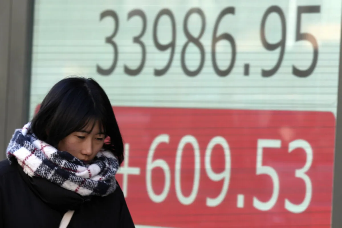 A person walks in front of an electronic stock board showing Japan's Nikkei 225 index at a securities firm in Tokyo on Jan. 9, 2024. (Eugene Hoshiko/AP Photo)