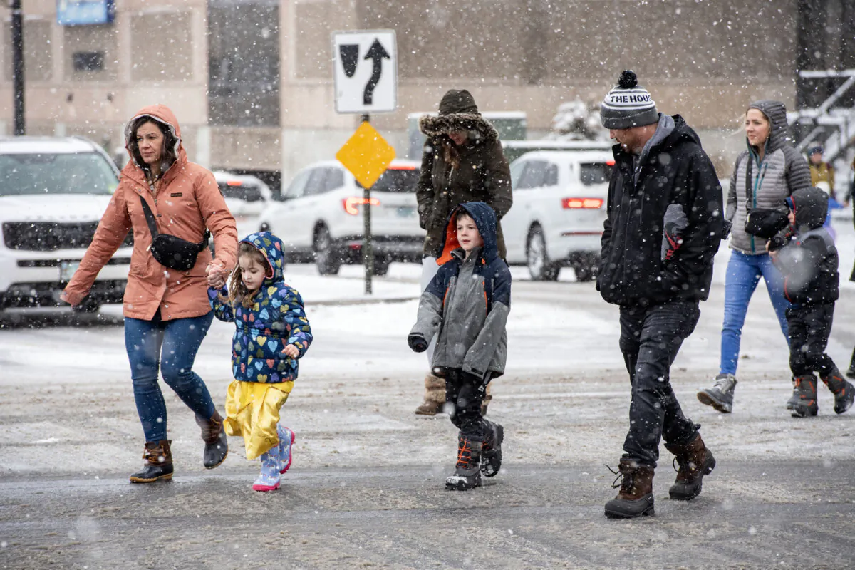 People make their way across the snowy street to the Southern New Hampshire University Arena to see a show in Manchester, N.H., on Jan. 7, 2024. (Joseph Prezioso/AFP via Getty Images)