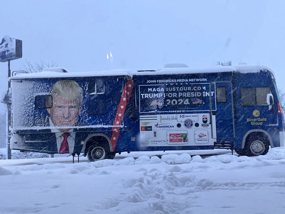 A tour bus for the John Fredricks Media Network sits outside the Hampton Inn Des Moines Airport amid a winter storm that dumped at least eight inches of snow on the ground on Jan. 9, 2024. (Janice Hisle/The Epoch Times)