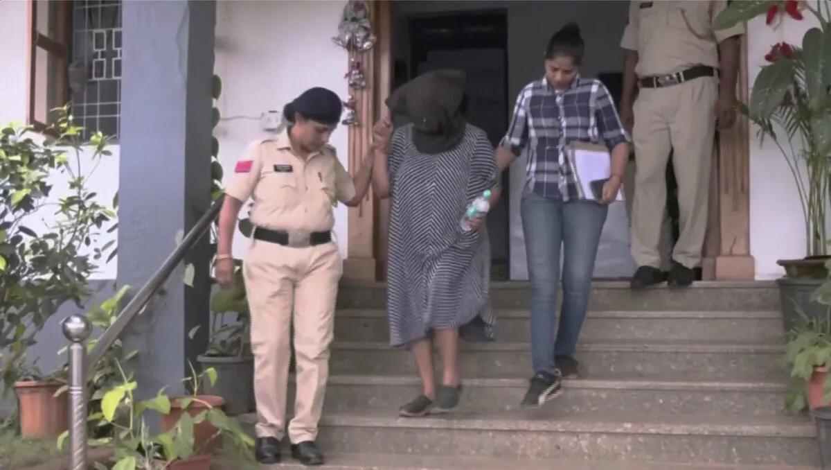 Suchana Seth, CEO of The Mindful AI Lab, walks with her face covered and is escorted by police into a vehicle in Calangute, Goa, India, on Jan. 9, 2023, in a still from video. (ANI via Reuters/Screenshot via NTD) 
