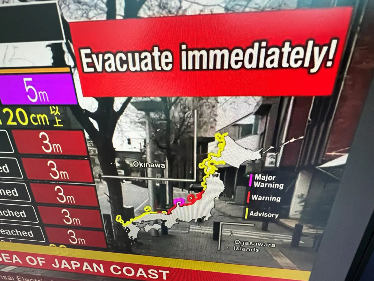 This image taken in Hong Kong shows a warning message on a screen from a live feed on NHK World asking people to evacuate from the area after a series of major earthquakes hit central Japan, on Jan. 1, 2024. (Mladen Antonov /AFP via Getty Images)