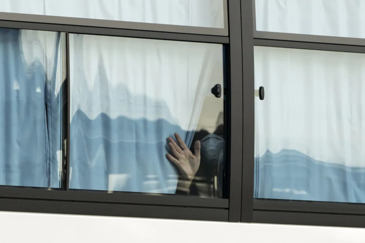 A man waves from a bus carrying passengers who disembarked the quarantined Diamond Princess cruise ship as it leaves the Daikoku Pier, in Yokohama, Japan, on Feb. 19, 2020. (Tomohiro Ohsumi/Getty Images)