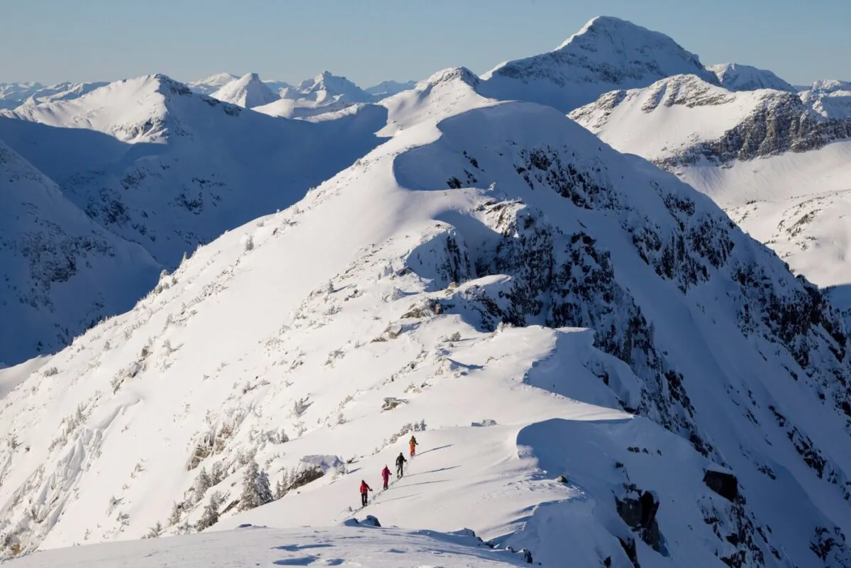 Backcountry skiers are dwarfed by the mountains as they make their way along a mountain ridge near McGillivray Pass Lodge located in the southern Chilcotin Mountains of British Columbia, on Jan. 10, 2012. (The Canadian Press/Jonathan Hayward)