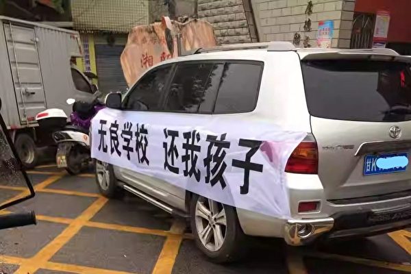 A van with a banner read “unscrupulous school, return my child” parked in front of Zhongshan Vocational School. (Supplied)