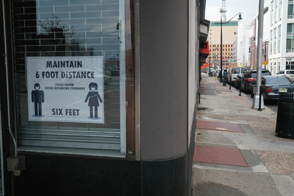 A sign asks people to keep six feet of distance in downtown Newark, N.J., on on Nov. 25, 2020. (Spencer Platt/Getty Images)