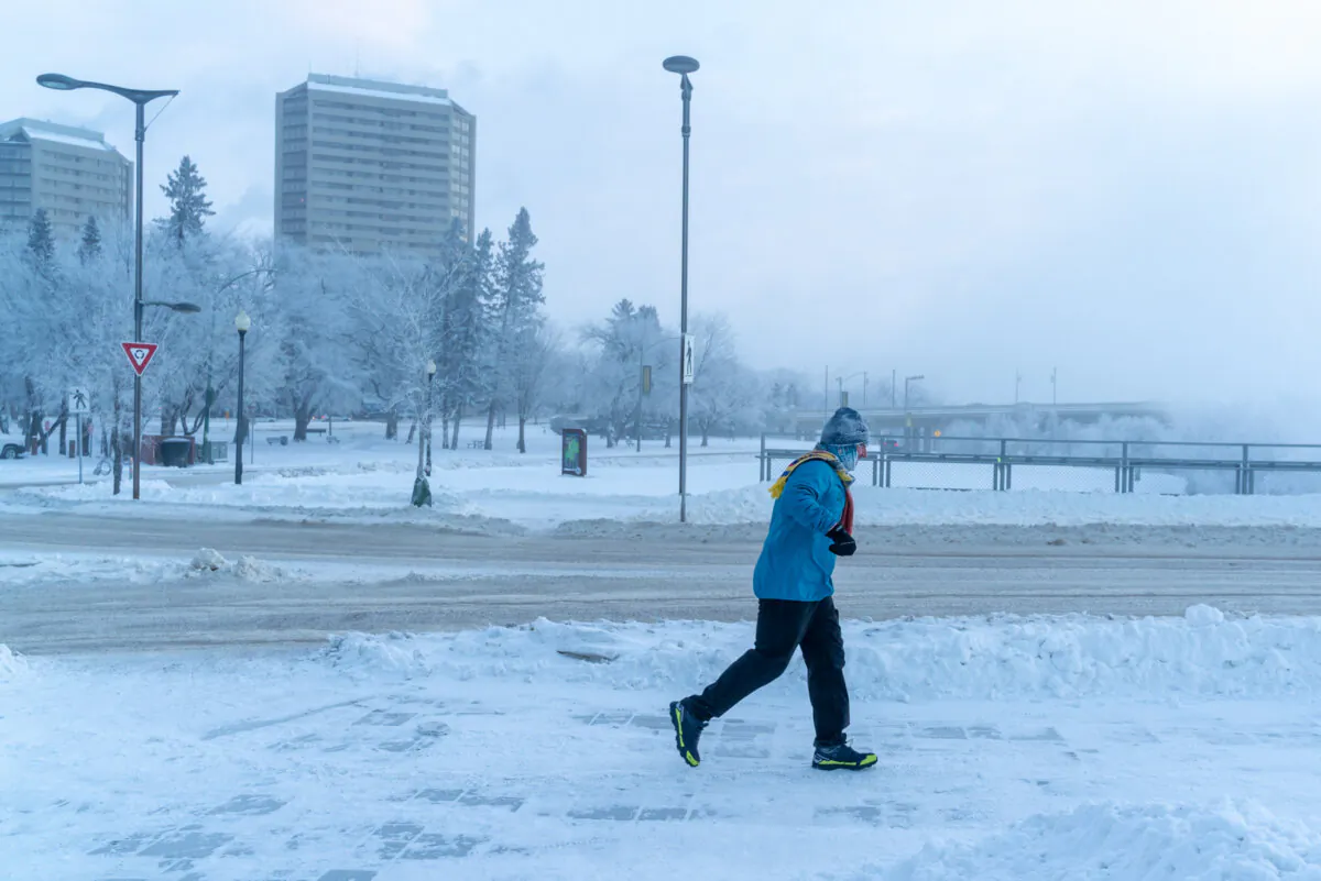 A pedestrian runs during an extreme cold warning in Saskatoon on Dec. 30, 2021. (The Canadian Press/Heywood Yu)