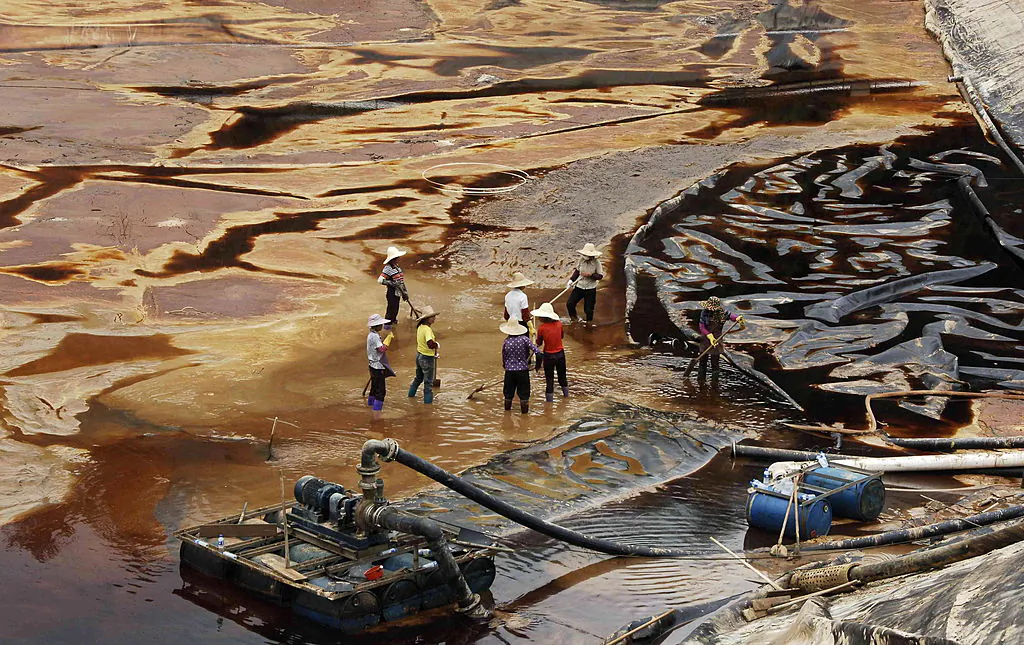 Workers drain away polluted water near the Zijin copper mine in Shanghang on July 13, 2010. Zijin Mining Group is acquiring a 15 percent stake for $130 million in the Canadian critical minerals development firm Solaris Resources Inc. through private placement on Jan. 11, 2024. (STR/AFP via Getty Images)