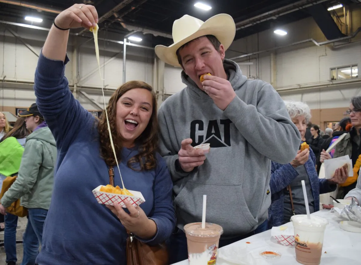 Sierra Patterson and Ross Marchese dig into some fresh fried mozzarella cubes and milk shakes. The North Carolina couple tries to attend the Pennsylvania Farm Show every year, in Harrisburg, Penn., on Jan. 11, 2024. (Beth Brelje/The Epoch Times)       