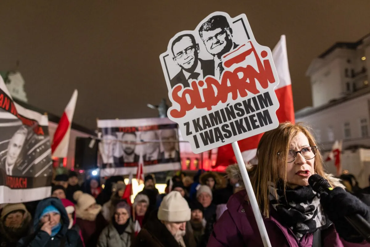A woman holds a banner reading "Solidarity with Kaminski and Wasik" to protest in front of the Presidential Palace, where supporters of the Law and Justice (PiS) party take part in a demonstration in support of former Interior Minister Mariusz Kaminski and his deputy Maciej Wasik after their arrest, in Warsaw, on Jan. 10, 2024. (Wojtek Radwanski//AFP via Getty Images)