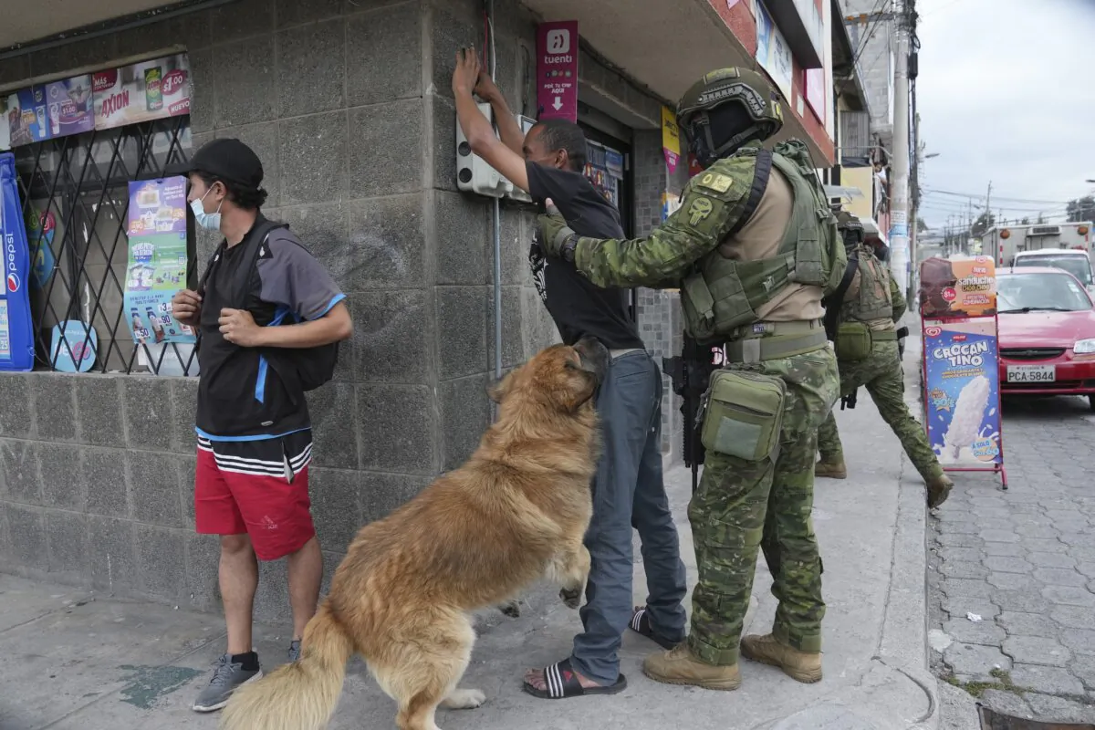 Soldiers stop a pedestrian to search for weapons as the man's dog jumps around, during military patrols in residential areas of northern Quito, Ecuador, on Jan. 11, 2024. (Dolores Ochoa/AP Photo)