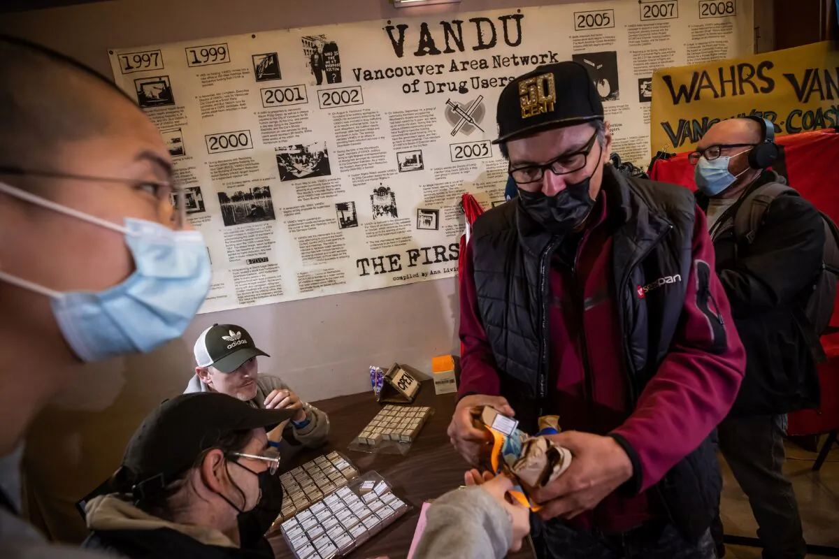 Supplies of illicit drugs are handed out to drug users after a gathering to remember those who died from a suspected overdose, in Vancouver on Feb. 9, 2022. (The Canadian Press/Darryl Dyck)
