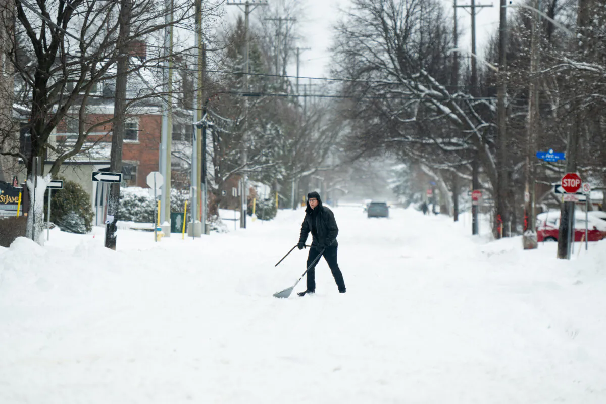 A person clears snow in The Glebe neighbourhood of Ottawa on Jan. 13, 2024. (The Canadian Press/Spencer Colby