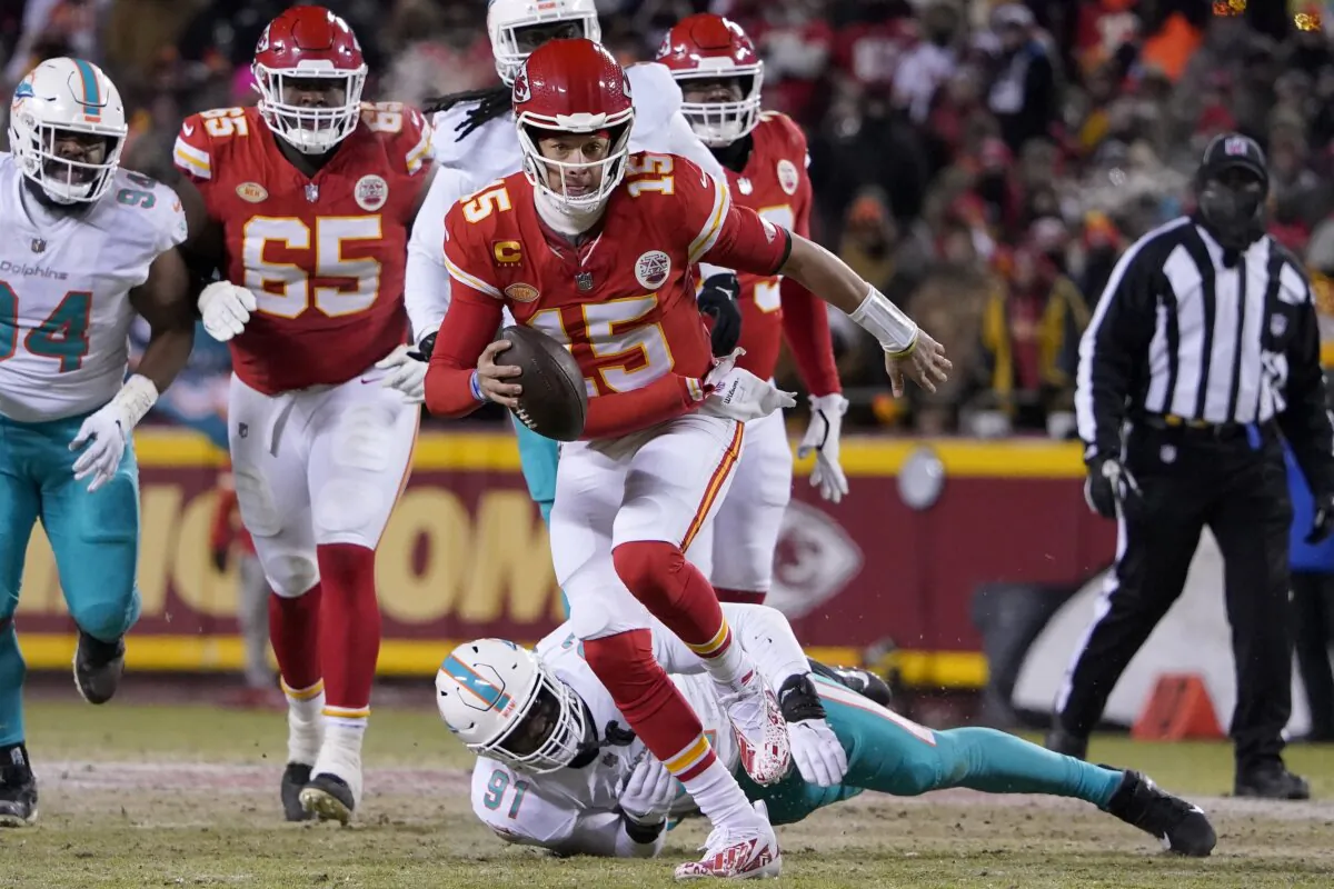 Kansas City Chiefs quarterback Patrick Mahomes (15) runs in front of Miami Dolphins defensive end Emmanuel Ogbah (91) during the first half of an NFL wild-card playoff football game in Kansas City on Jan. 13, 2024. (Ed Zurga/AP Photo)