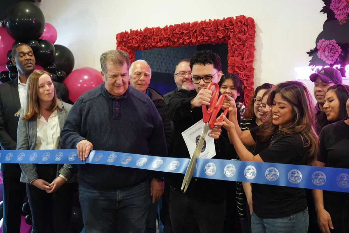 Middletown Mayor Joseph DeStefano (C) holds the ribbon that Alan Ortiz (2nd R) and Itzel Flores (R) cut at the opening ceremony of their new restaurant, House of Birria, in Middleotown, N.Y., on Jan. 13, 2024. (Cara Ding/The Epoch Times)
