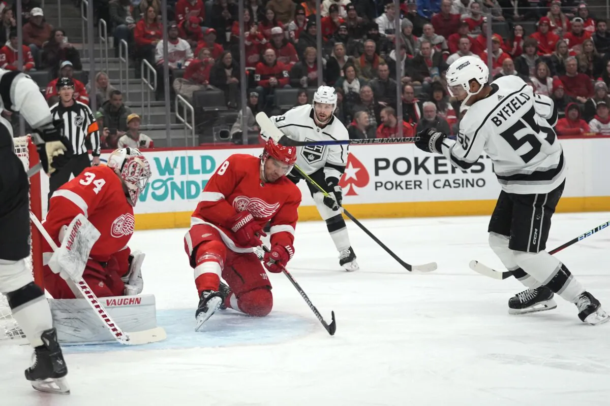 Los Angeles Kings right wing Quinton Byfield (55) scores on Detroit Red Wings goaltender Alex Lyon (34) as Ben Chiarot (8) defends in the first period of an NHL hockey game in Detroit on Jan. 13, 2024. (Paul Sancya/AP Photo)