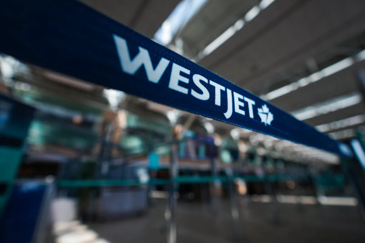 A WestJet logo is seen in the domestic check-in area at Vancouver International Airport in Richmond, B.C., on May 19, 2023. (The Canadian Press/Darryl Dyck)