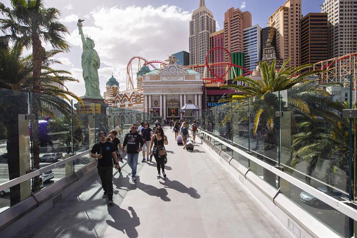 People walk along the pedestrian bridge between the New York-New York and the MGM Grand on Monday, March 28, 2022, in Las Vegas. (Chase Stevens/Las Vegas Review-Journal)