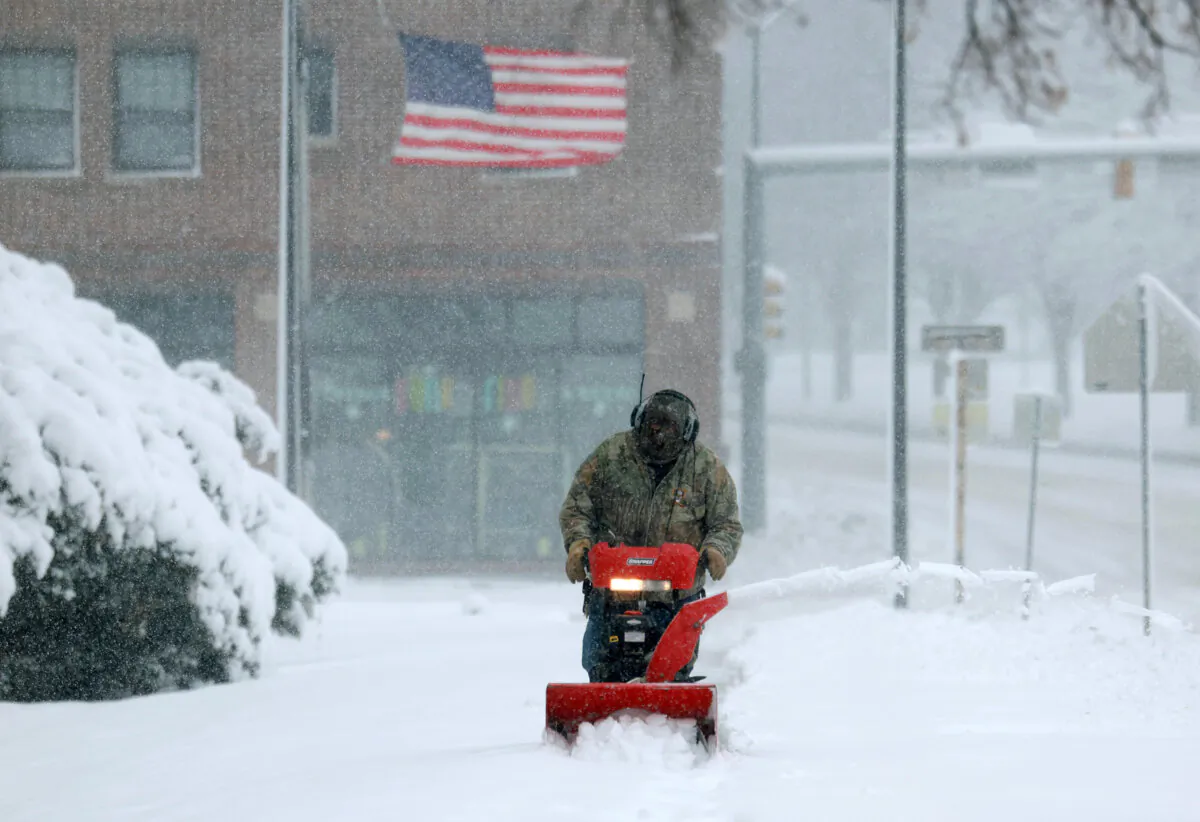 A person uses a snowblower to clear a sidewalk as a snowstorm dumps several inches of snow on the area in Des Moines, Iowa, on Jan. 9, 2024. (Joe Raedle/Getty Images)
