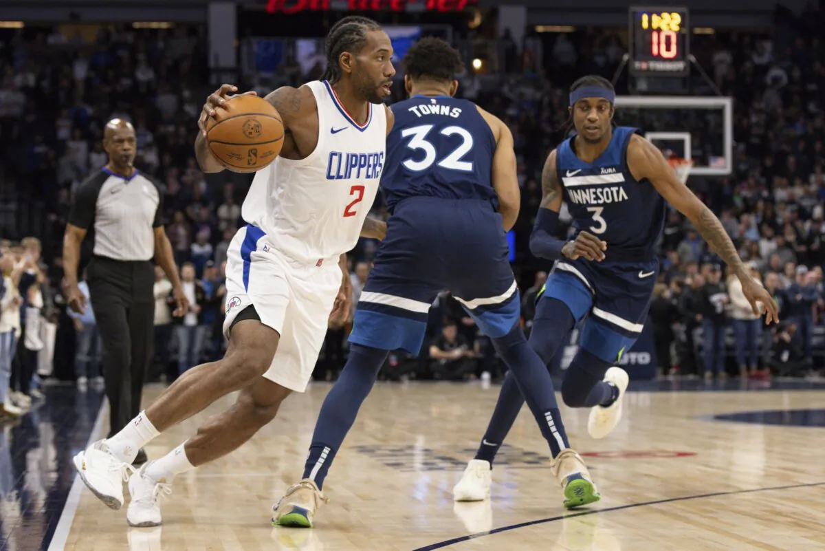 Los Angeles Clippers forward Kawhi Leonard (2) drives to the basket around Minnesota Timberwolves center Karl-Anthony Towns (32) and forward Jaden McDaniels (3) during the first half of an NBA basketball game in Minneapolis on Jan. 14, 2024. (Bailey Hillesheim/AP Photo)