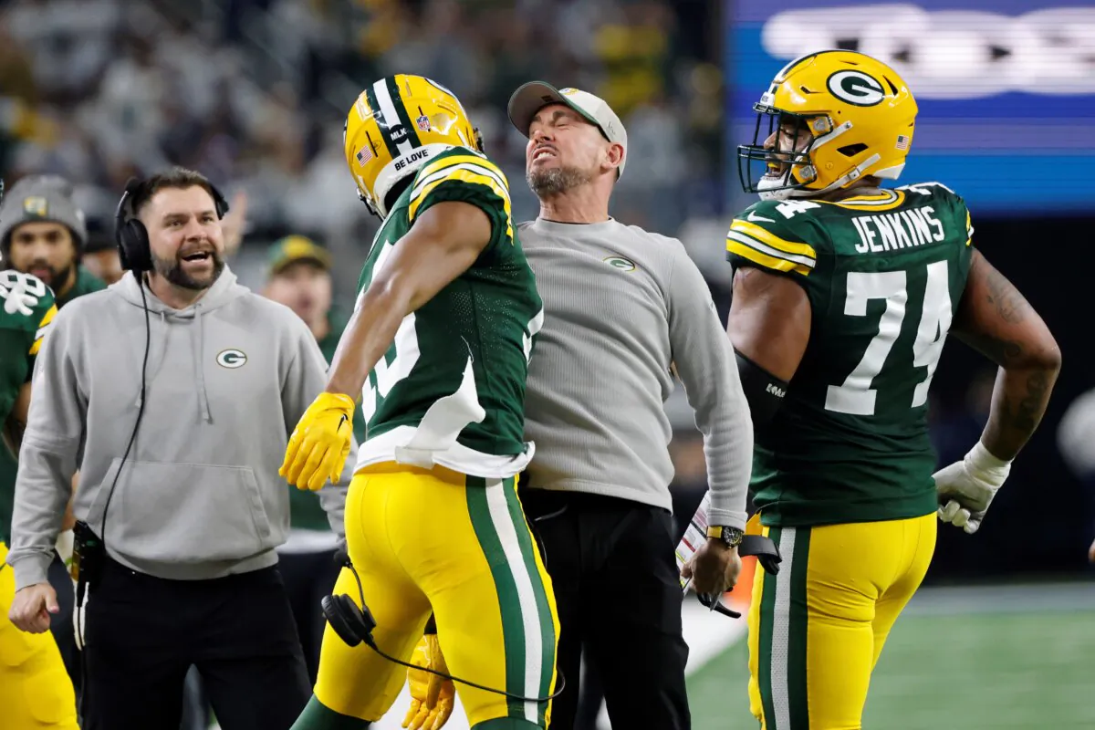 Green Bay Packers head coach Matt LaFleur, center right, bumps chests with wide receiver Dontayvion Wicks, center left, after Wicks caught a touchdown pass against the Dallas Cowboys during the first half of an NFL football game in Arlington, Texas on Jan. 14, 2024. (Michael Ainsworth/AP Photo)