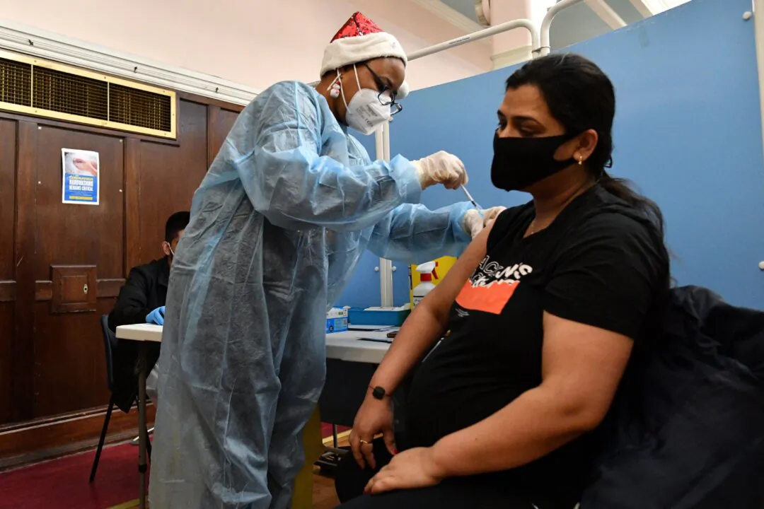 A health worker administers a dose of the COVID-19 vaccine to a pregnant woman at a pop-up vaccination centre at the Redbridge Town Hall, east London on Dec. 25, 2021. (Justin Tallis/AFP via Getty Images)