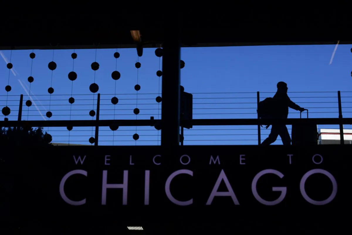 A passenger walks with luggage past holiday decorations at Chicago O'Hare International Airport in Chicago on Dec. 24, 2022. (Paul Beaty/AP Photo)